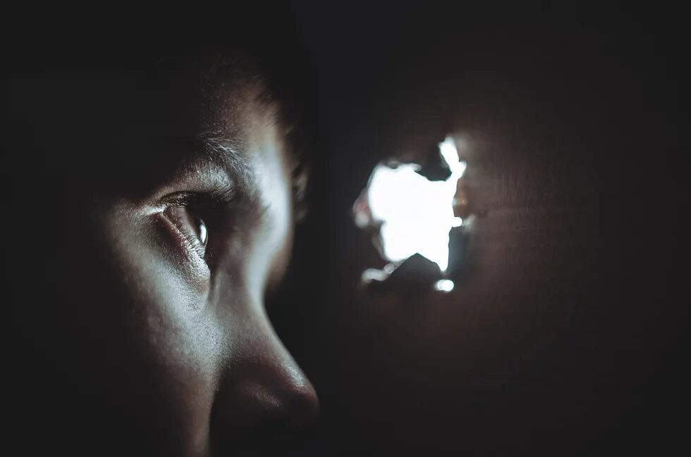 Un enfant qui regarde par un trou